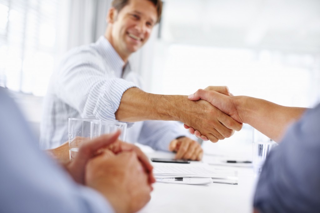 Portrait of business man shaking hands with colleague in meeting